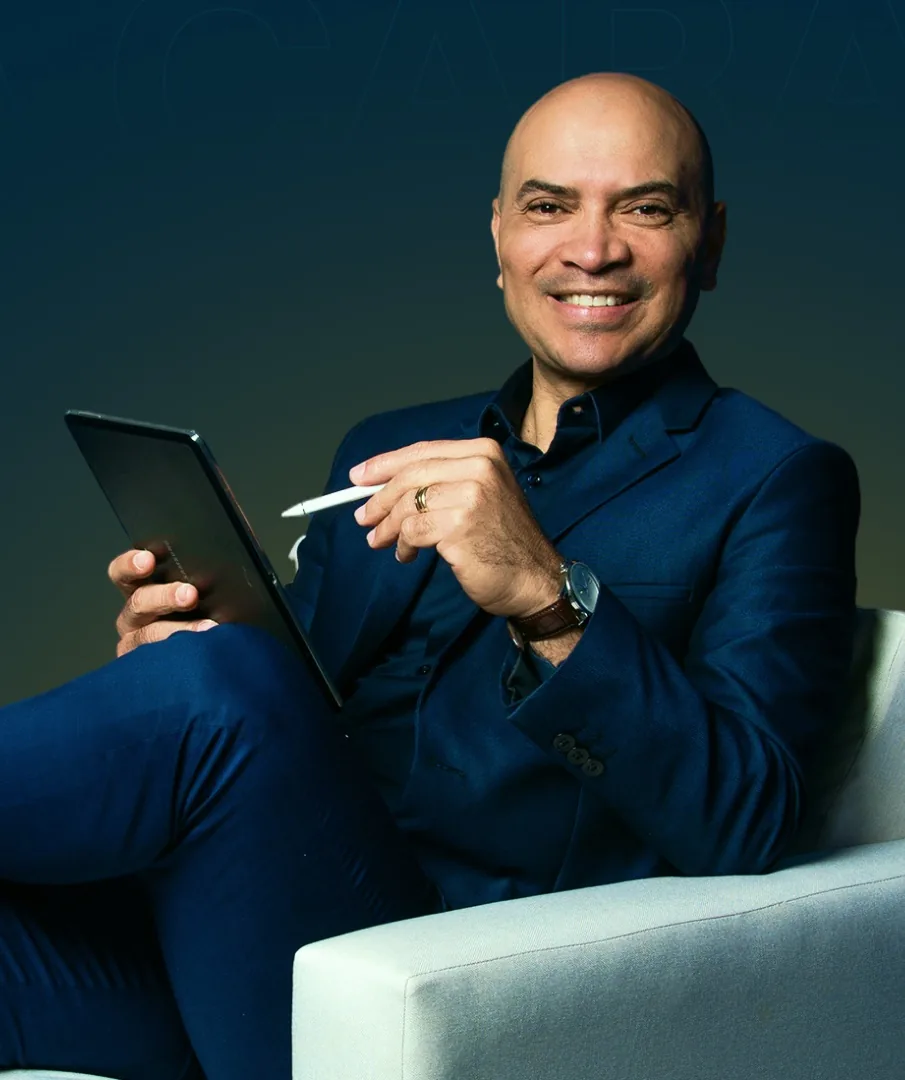 Pereira Amorim sentado, sorrindo, com um tablet nas mãos